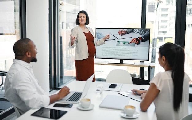 A group of retail employees participating in a loss prevention training session in a bright, modern conference room. The trainer is presenting information on a large screen.