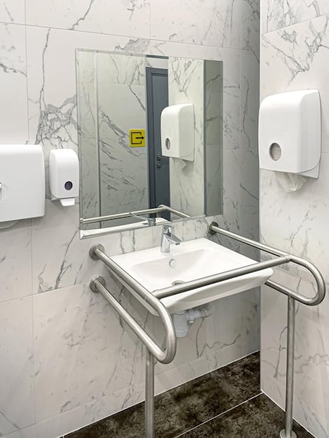 An accessible restroom interior featuring grab bars next to the toilet, an adjustable sink height, and clear signage with Braille. The restroom should be clean, well-lit, and free of obstructions.